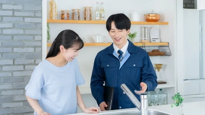 女性と作業員がキッチンで話してる